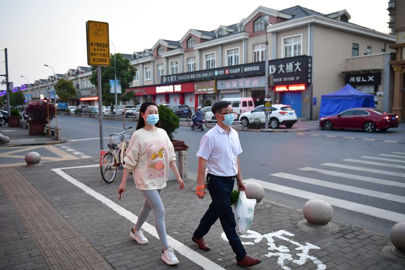 &copy; Reuters. Residents walk on a street in Fengjing town of Jinshan district, as the city eases the lockdown in some areas amid the coronavirus disease (COVID-19) outbreak, in Shanghai, China April 11, 2022.  Picture taken April 11, 2022. cnsphoto via REUTERS  