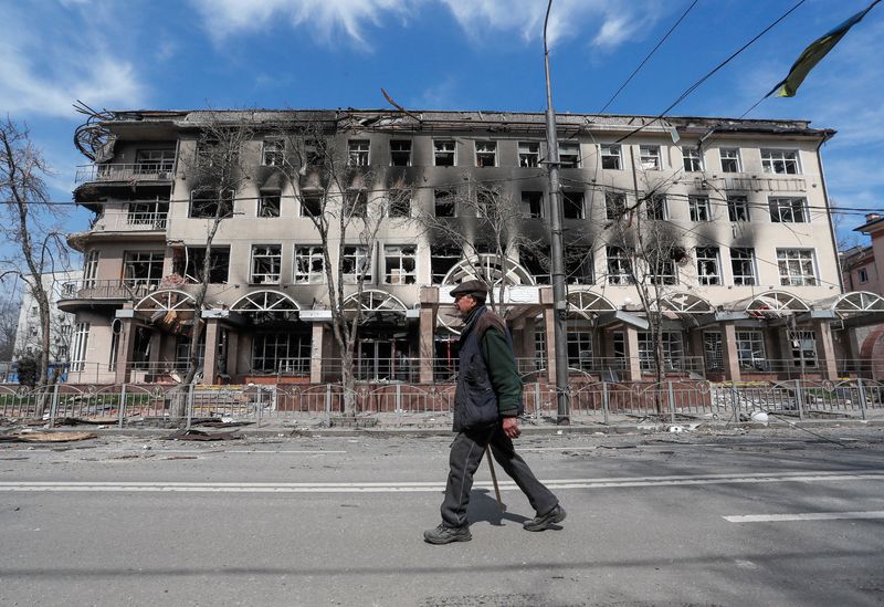 &copy; Reuters. رجل يسير أمام مبنى لحق به ضرر جراء القصف الروسي الأوكراني في مدينة ماريوبول يوم العاشر من أبريل نيسان 2022. تصوير: الكسندر إرموشينكو - رويترز.