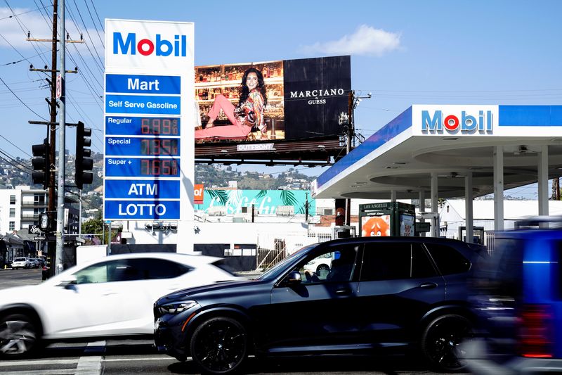 &copy; Reuters. FILE PHOTO: A vehicle waits in traffic next to displayed gasoline prices at a Mobil gas station in Beverly Boulevard in West Hollywood, California, U.S., March 10, 2022. Picture taken March 10, 2022. REUTERS/Bing Guan/File Photo