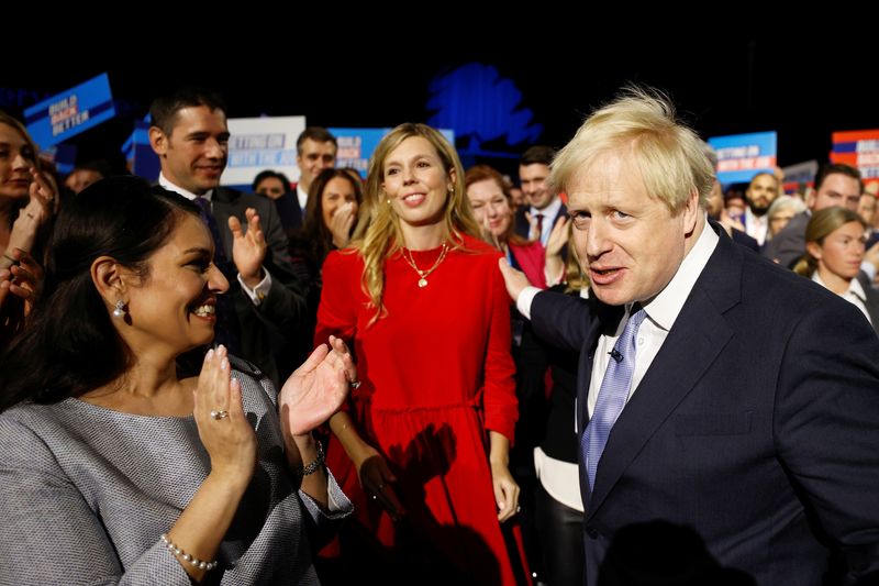 &copy; Reuters. FILE PHOTO: Britain's Prime Minister Boris Johnson arrives to deliver a speech during the annual Conservative Party Conference as his wife Carrie Johnson and Britain's Home Secretary Priti Patel look on, in Manchester, Britain, October 6, 2021. REUTERS/Ph