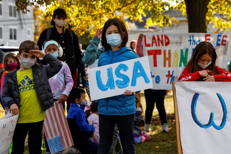 &copy; Reuters. FILE PHOTO: Children wearing protective face masks stand holding signs during a Veterans Day ceremony at the John Philip Sousa Memorial Bandshell at Sunset Park in Port Washington, New York, U.S. November 11, 2021. REUTERS/Shannon Stapleton