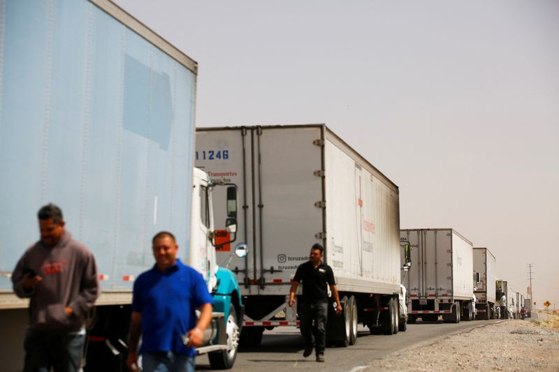 © Reuters. Truckers wait near their trailers as others block the Jeronimo-Santa Teresa International Bridge connecting the city of Ciudad Juarez to Santa Teresa, Nuevo Mexico, to protest against truck inspections imposed by Texas Governor Greg Abbott, in Ciudad Juarez, Mexico April 12, 2022. REUTERS/Jose Luis Gonzalez