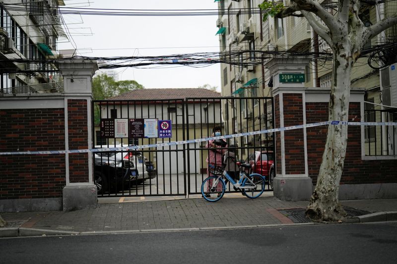 &copy; Reuters. 　４月１３日、中国・上海市は、新型コロナウイルス対策の厳格なロックダウン（都市封鎖）規則に違反する者は厳正に処罰すると警告した。写真は居住エリアへの入り口を塞ぐ門。上海で