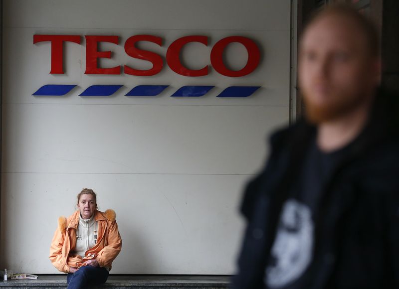 &copy; Reuters. FILE PHOTO: Woman sits under a logo of Tesco supermarket in Budapest, Hungary February 29, 2016. REUTERS/Laszlo Balogh