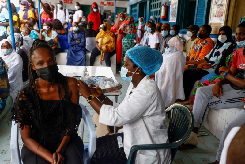 &copy; Reuters. FILE PHOTO: Aminata Laye Diagne, a nurse gives a dose of coronavirus disease (COVID-19) vaccine to a woman at Philippe Senghor Hospital  in Dakar, amid a surge of coronavirus disease (COVID-19) cases in Senegal July 28, 2021. REUTERS/Zohra Bensemra