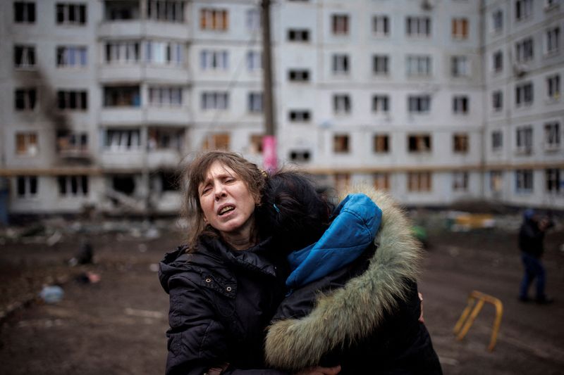&copy; Reuters. Una mujer reacciona mientras abraza a otra en el exterior de un bloque de apartamentos fuertemente dañado, tras un ataque de artillería, en medio del ataque de Rusia a Ucrania, en Járkov, Ucrania. 13 de abril de 2022. REUTERS/Alkis Konstantinidis