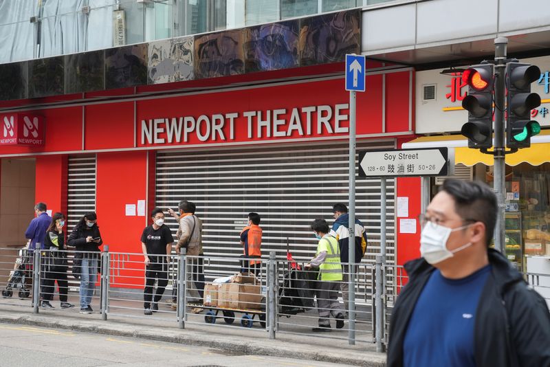 &copy; Reuters. FOTO DE ARCHIVO: Personas con mascarilla frente a un cine cerrado en Hong Kong, el 16 de febrero de 2022. REUTERS/Lam Yik