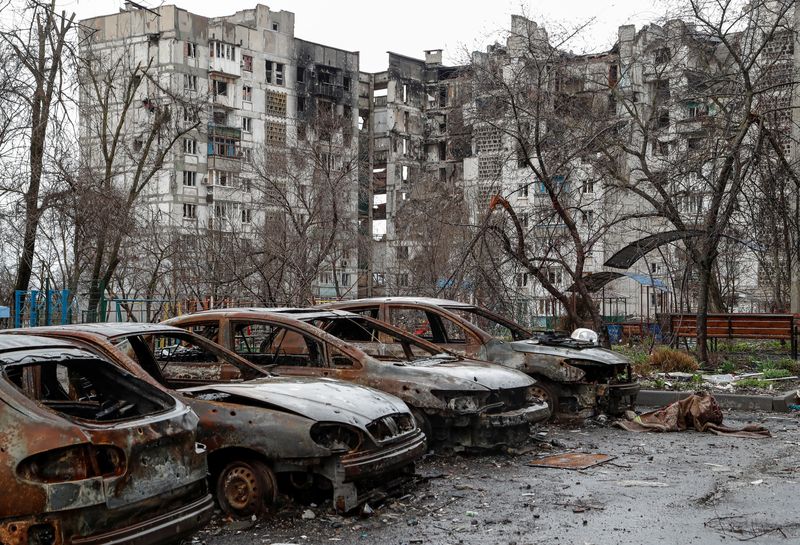 © Reuters. سيارات محترقة أمام بمنى سكني تضرر خلال الصراع بين روسيا وأوكرانيا في ماريوبول يوم الأربعاء. تصوير: أكلسندر إيرموتشنكو - رويترز
