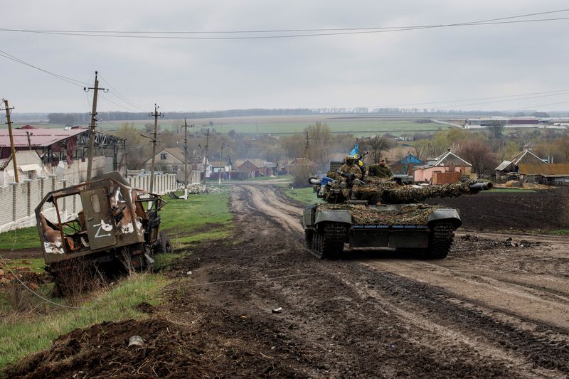 &copy; Reuters. Foto de un tanque ucraniano pasando cerca de un vehículo ruso destruido en la localidad de Husarivka
Abril 14, 2022. REUTERS/Alkis Konstantinidis