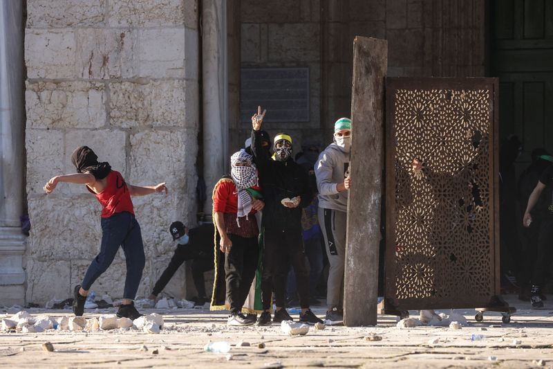 © Reuters. فلسطينيون يرشقون قوات الأمن الإسرائيلية بالحجارة خلال اشتباكات في ساحات الأقصى بالقدس يوم الجمعة. تصوير: عمار عوض - رويترز. 