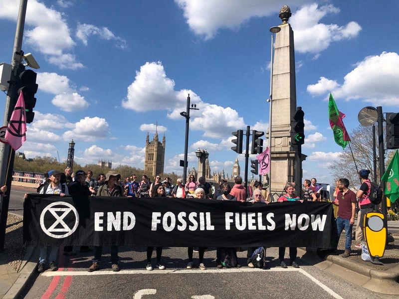 © Reuters. Activists from the Extinction Rebellion hold a banner as they block Lambeth Bridge during the Just Stop Oil protest in London, Britain, April 15, 2022.    Extinction Rebellion/Handout via REUTERS    