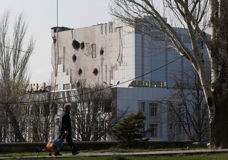 © Reuters. A local resident walks past the Palace of Culture damaged during Ukraine-Russia conflict in the southern port city of Mariupol, Ukraine April 15, 2022. REUTERS/Alexander Ermochenko