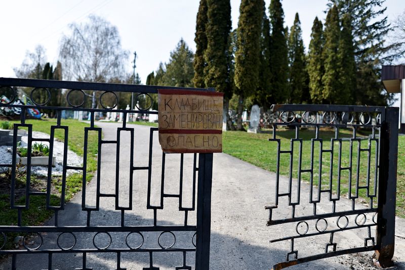 &copy; Reuters. لافتة كتبت بخط اليد على البوابة مكتوب عليها "خطر.. المقبرة ملغومة" في بلدة تروستيانيتس في منطقة سومي بشمال أوكرانيا في صورة التقطت يوم السبت. 