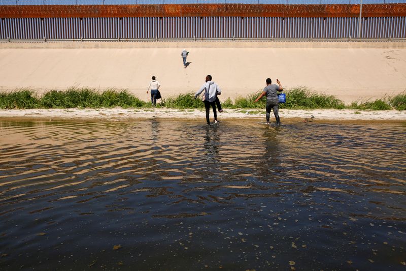 &copy; Reuters. Imagen de archivo de migrantes caminando por el río Bravo luego de cruzarlo para entregarse a agentes de la Patrulla Fronteriza de Estados Unidos para solicitar asilo en El Paso, Texas, Estados Unidos, vistos desde Ciudad Juárez, México. 13 de abril, 2