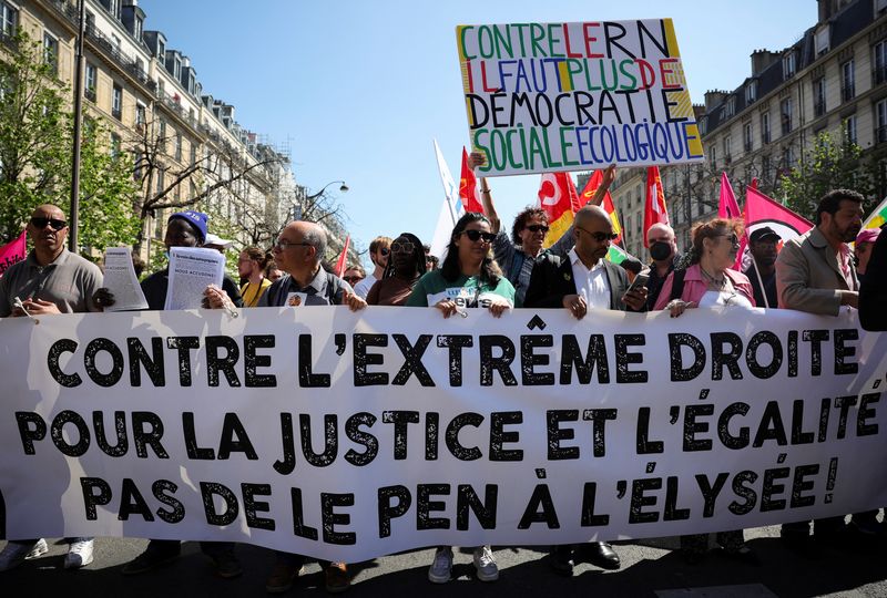 &copy; Reuters. Gente asiste a una manifestación contra la extrema derecha, el racismo y el fascismo antes de la segunda vuelta de la elección presidencial 2022, en París, Francia. 16 de abril, 2022. La pancarta dice "Contra la extrema derecha, por la justicia e igual