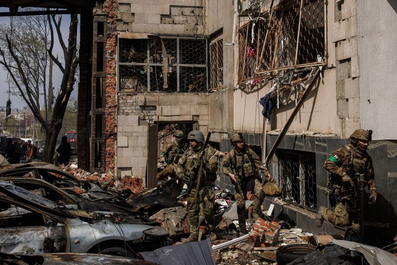 &copy; Reuters. Soldados ucranianos caminan entre los escombros luego de un ataque de artillería ruso, mientras continúa el ataque de Rusia contra Ucrania, en Járkov, Ucrania. 16 de abril, 2022. REUTERS/Alkis Konstantinidis