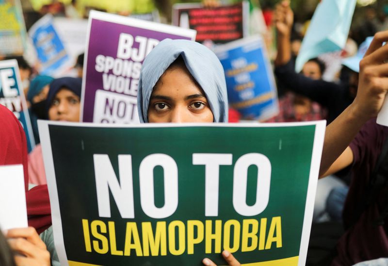 &copy; Reuters. FILE PHOTO: A citizen holds a placard during a peace vigil organised by citizens against what they say is rise in hate crimes and violence against Muslims in the country, in New Delhi, India, April 16, 2022. REUTERS/Anushree Fadnavis