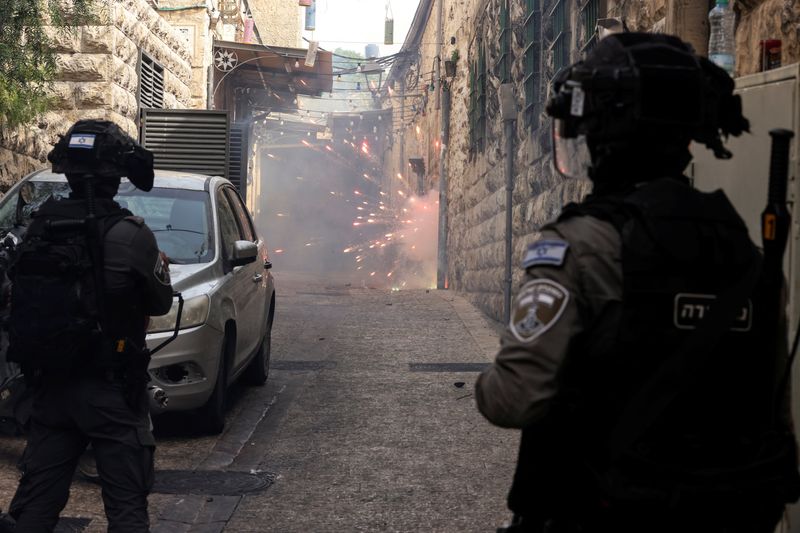&copy; Reuters. Israeli border police force stand by as Palestinian protestors shoot fireworks towards them in an alley in Jerusalem's Old City April 17, 2022. REUTERS/Ammar Awad