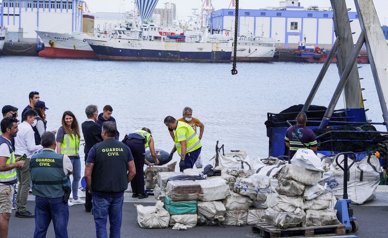&copy; Reuters. أفراد الشرطة يفرغون المخدرات من قارب الصيد إيه.كيه.تي 1 في ميناء لاس بالماس في جزيرة جران كناريا بإسبانيا يوم السبت. تصوير: بورجا سواريز - روي