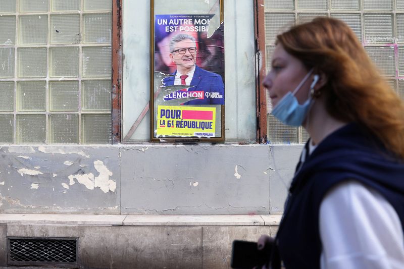 © Reuters. امرأة تمر أمام ملصق انتخابي لمرشح أقصى اليسار جان لوك ميلونشون في انتخابات الرئاسة الفرنسية وذلك قرب باريس يوم 14 أبريل نيسان 2022. تصوير: يوهانا جيرون-رويترز.
