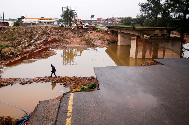 &copy; Reuters. FILE PHOTO: A man walks around a damaged bridge caused by flooding in Umlazi near Durban, South Africa, April 16, 2022. REUTERS/Rogan Ward/File Photo