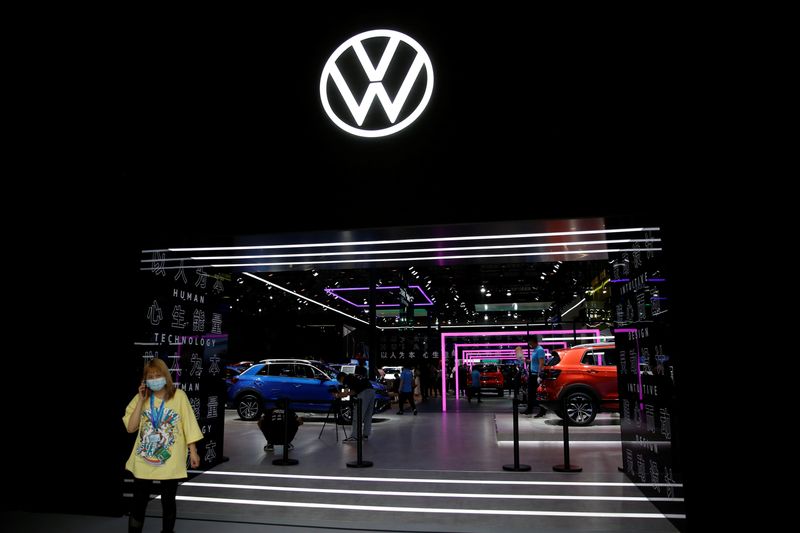 &copy; Reuters. FILE PHOTO: A woman wearing a face mask following the coronavirus disease (COVID-19) outbreak stands under a sign of Volkswagen at the Beijing International Automotive Exhibition, or Auto China show, in Beijing, China, September 27,  2020. REUTERS/Tingshu