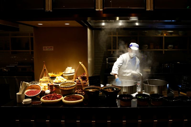 &copy; Reuters. FILE PHOTO: A chef wearing a mask and a face shield as protection against the coronavirus disease (COVID-19) cooks in the restaurant of a hotel inside the closed loop at the Beijing 2022 Winter Olympics in Beijing, China, February 1, 2022.   REUTERS/Thoma