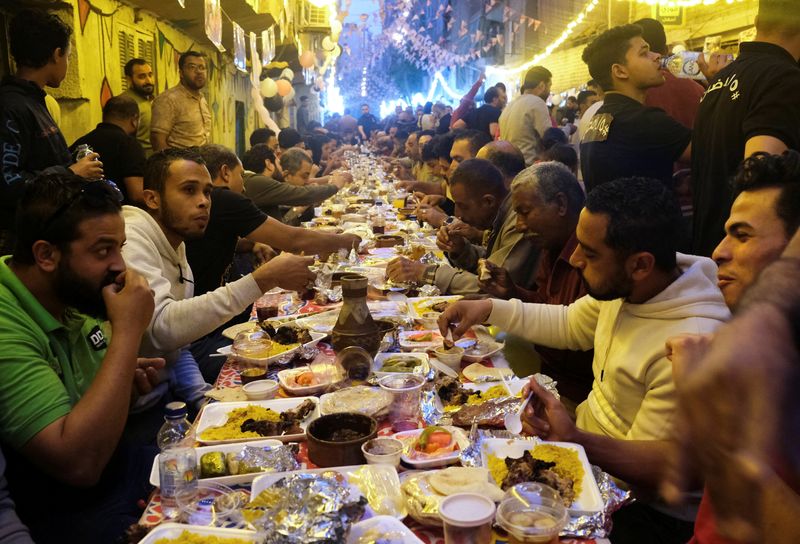 &copy; Reuters. سكان عزبة حمادة يجتمعون على مائدة الرحمن لتناول طعام الإفطار خلال شهر رمضان المبارك في المطرية بالقاهرة يوم 16 أبريل نيسان 2022. تصوير: فاطمة ف
