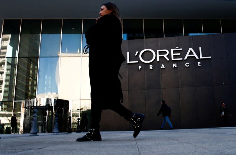 &copy; Reuters. FILE PHOTO: A woman walks by the logo of French cosmetics group L'Oreal in the western Paris suburb of Levallois-Perret, France, February 7, 2020. REUTERS/Gonzalo Fuentes/File Photo 