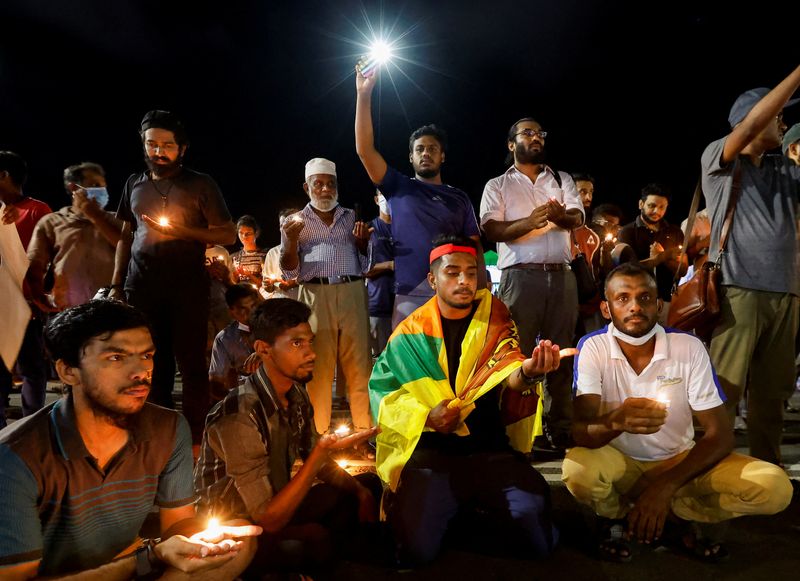 © Reuters. Demonstrators flash flashlight and hold candles during a candlelight vigil after Sri Lankan police fired live ammunition to scatter protesters killing one person and injuring a dozen more, near the Presidential Secretariat, amid the country's economic crisis, in Colombo, Sri Lanka, April 19, 2022. REUTERS/Navesh Chitrakar