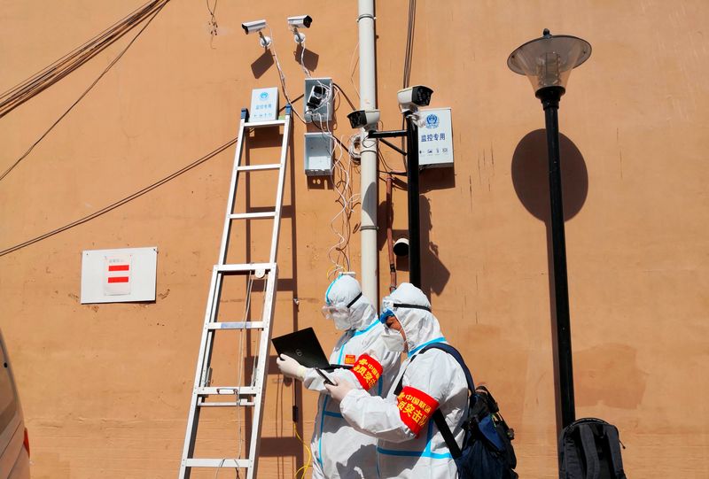&copy; Reuters. FILE PHOTO: Workers set up surveillance cameras at a residential compound following cases of the coronavirus disease (COVID-19) in Mudanjiang, Heilongjiang province, China April 14, 2022. China Daily via REUTERS 