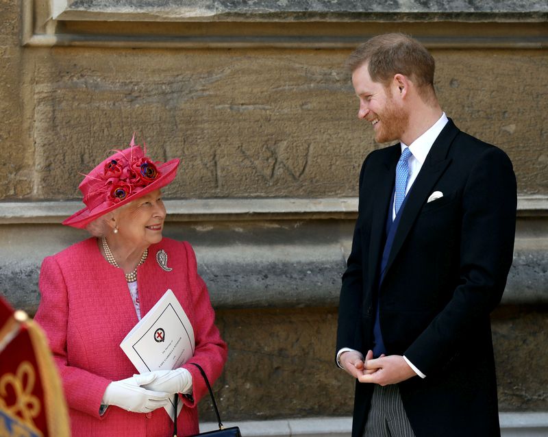 © Reuters. الملكة إليزابيث تتحدث إلى الأمير هاري أثناء مغادرتهما حفل زفاف في كنيسة سان جورج في قلعة وندسور بالقرب من لندن. صورة من أرشيف رويترز