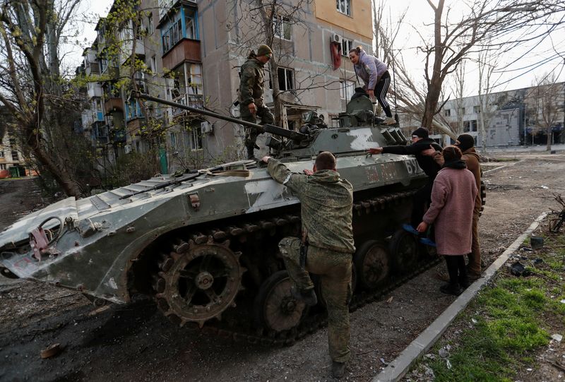 &copy; Reuters. Foto de arcchivo de soldados prorrusos ayudando a civiles a subir a un tanque en Mariupol
Abril 17, 2022. REUTERS/Alexander Ermochenko