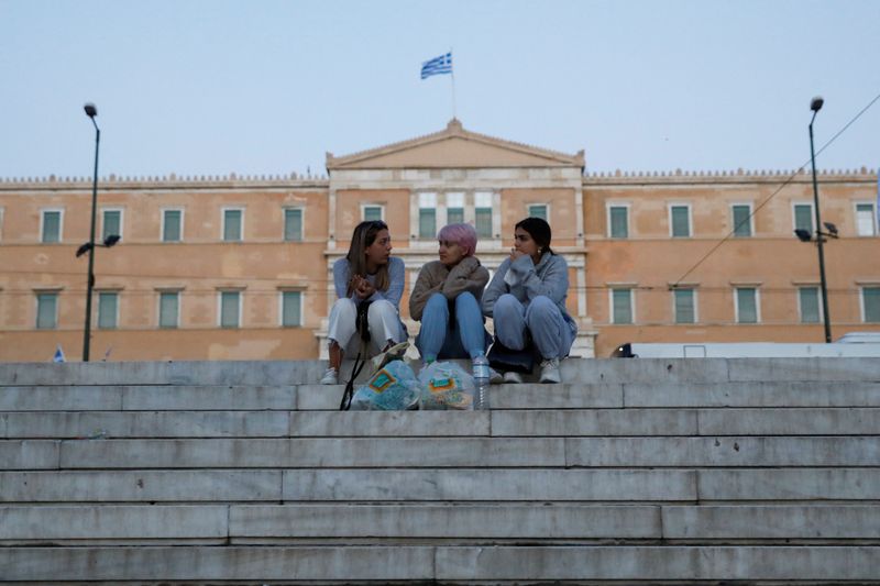 &copy; Reuters. People sit at Syntagma square where the parliament building is seen in the background, in Athens, Greece April 20, 2022. REUTERS/Costas Baltas