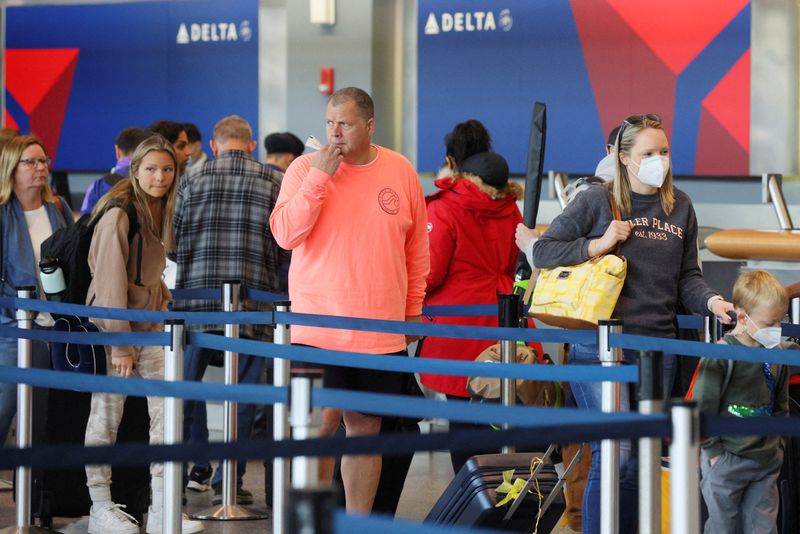 &copy; Reuters. FILE PHOTO: Travellers wearing masks and not wearing masks wait in line at a Delta Airlines counter, after a federal judge in Florida struck down the CDC's public transportation masking order due to the coronavirus disease (COVID-19) prevention efforts, a