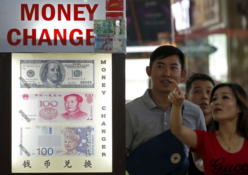 &copy; Reuters. FILE PHOTO: People look at the exchange rate at a moneychanger displaying a poster of U.S. dollar bill, Chinese Yuan and Malaysia Ringgit in Singapore August 24, 2015.  REUTERS/Edgar Su