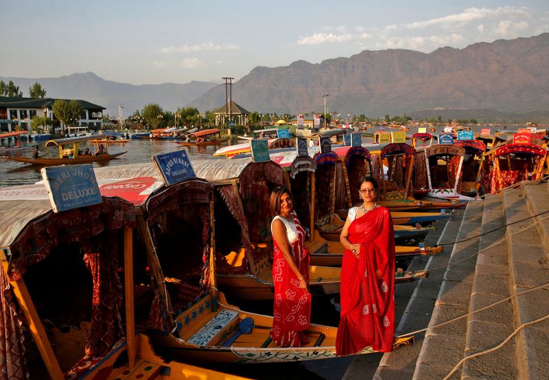 &copy; Reuters. FILE PHOTO: Tourists pose on parked "Shikaras" or boats on the banks of Dal Lake in Srinagar, April 5, 2022. REUTERS/Danish Ismail