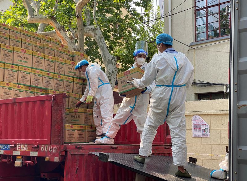 © Reuters. People in protective suits unload boxes labeled soy sauce from a truck, following the coronavirus disease (COVID-19) outbreak in Shanghai, China April 21, 2022. REUTERS/Andrew Galbraith