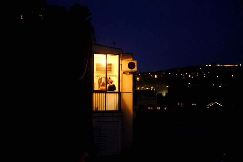 &copy; Reuters. FILE PHOTO: Illuminated house is pictured near the air conditioning as a family stand in Barcelona, Spain September 14, 2021. REUTERS/Nacho Doce/File Photo