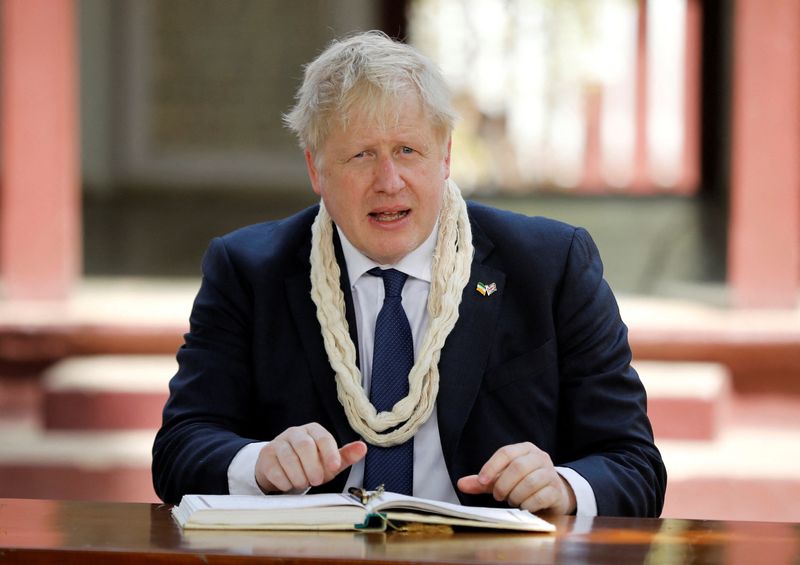 &copy; Reuters. Britain's Prime Minister Boris Johnson, wearing a garland made of cotton thread, looks on after signing the guest book during his visit to Gandhi Ashram in Ahmedabad, India, April 21, 2022. REUTERS/Amit Dave