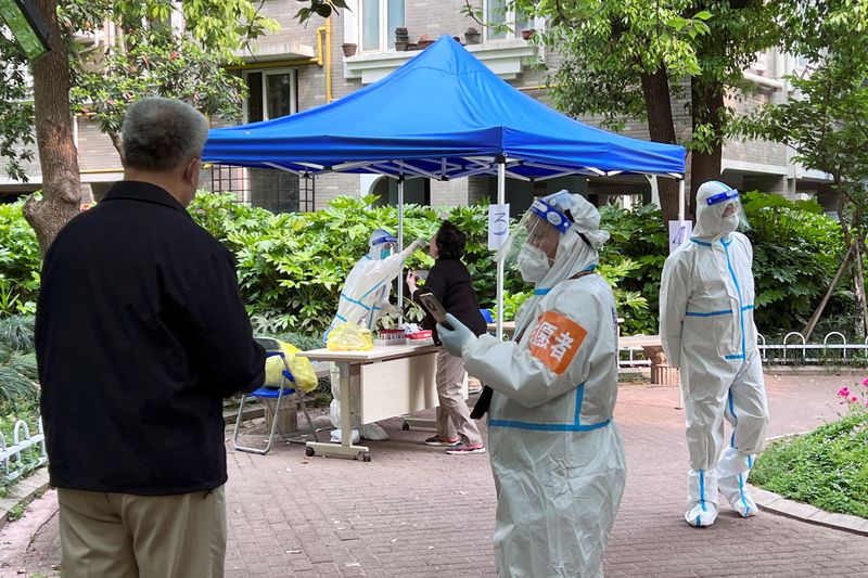 &copy; Reuters. FILE PHOTO: A medical worker in a protective suit collects swab from a resident at a makeshift nucleic acid testing site inside a residential compound under lockdown, amid the coronavirus disease (COVID-19) outbreak in Shanghai, China April 19, 2022. REUT