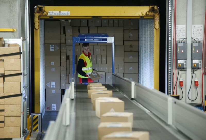 © Reuters. FILE PHOTO: An employee puts parcels on a conveyor belt at a new DHL/Deutsche Post parcel center in Bochum, Germany, November 18, 2019. REUTERS/Leon Kuegeler