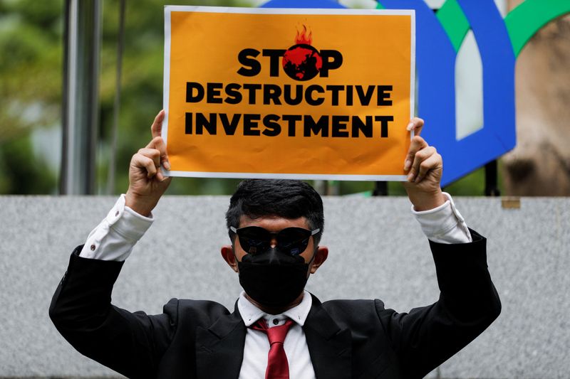 &copy; Reuters. Un activista sostiene una pancarta en la que se lee en inglés "Detened las inversiones destructivas", durante una protesta bajo el lema "Inversiones para la Tierra, no para la oligarquía" en demanda de inversiones sostenibles frente al Ministerio de Inv