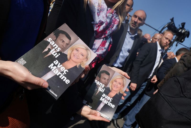 &copy; Reuters. Des partisans de Marine Le Pen tiennent des tracts de sa campagne lors d'une visite d'un marché local à Etaples. Il y a celle qui provoquerait "une guerre civile", et celui qui "n'aime pas les Français": au dernier jour de la campagne de l'élection pr