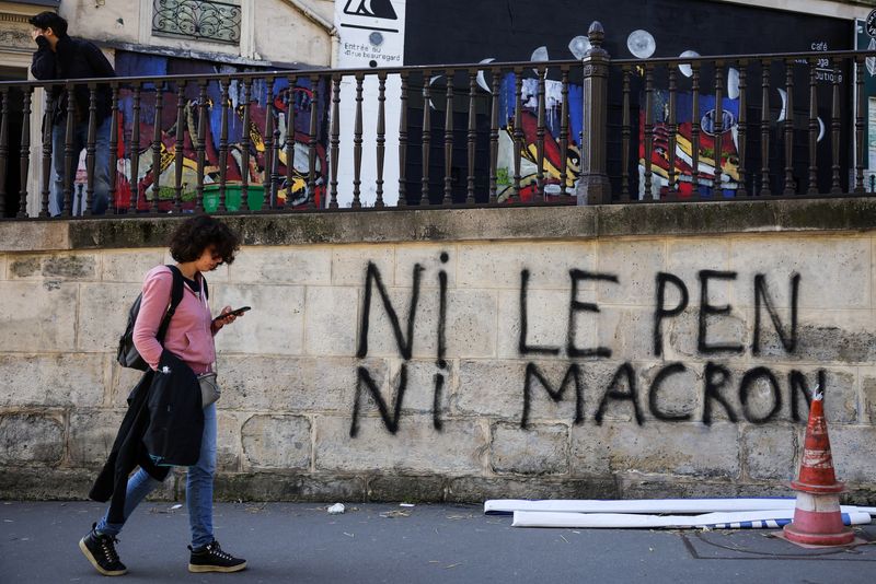 &copy; Reuters. A person walks past a graffiti reading "neither Le Pen nor Macron" while activists from Extinction Rebellion occupy the Porte Saint Denis, as part of an action to demand ecological and social justice ahead of the second round of the 2022 presidential elec