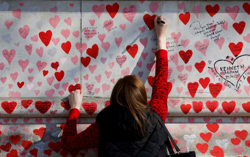 &copy; Reuters. FILE PHOTO: A person writes a message on The National Covid Memorial Wall, on national day of reflection to mark the two year anniversary of the United Kingdom going into national lockdown, in London, Britain, March 23, 2022. REUTERS/Peter Cziborra