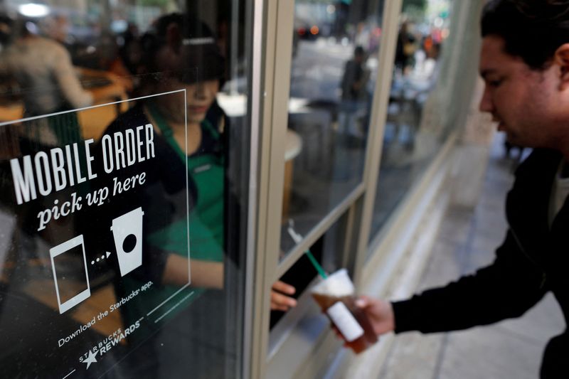 &copy; Reuters. FILE PHOTO: A customer picks up his smartphone order from a Starbucks coffee shop in downtown Los Angeles, California, U.S., March 15, 2018. REUTERS/Mike Blake