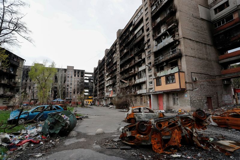 &copy; Reuters. صورة للدمار الذي لحق بمباني سكنية ومركبات في ماريوبول يوم الجمعة. تصوير: الكسندر إرموتشينكو - رويترز. 