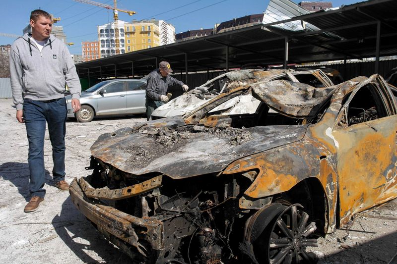 &copy; Reuters. Dos hombres inespeccionan varios autos destruidos por un ataque militar contra un edificio en Odesa, Ucrania. 24 abril 2022. REUTERS/Igor Tkachenko