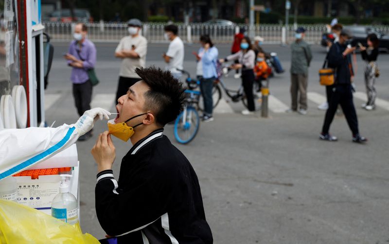 &copy; Reuters. 　４月２５日、中国北京市は２５日、市内最大の行政区である朝陽区で全住民・在勤者の新型コロナウイルス検査を開始した。写真は検査を受ける男性。北京で撮影（２０２２年　ロイター